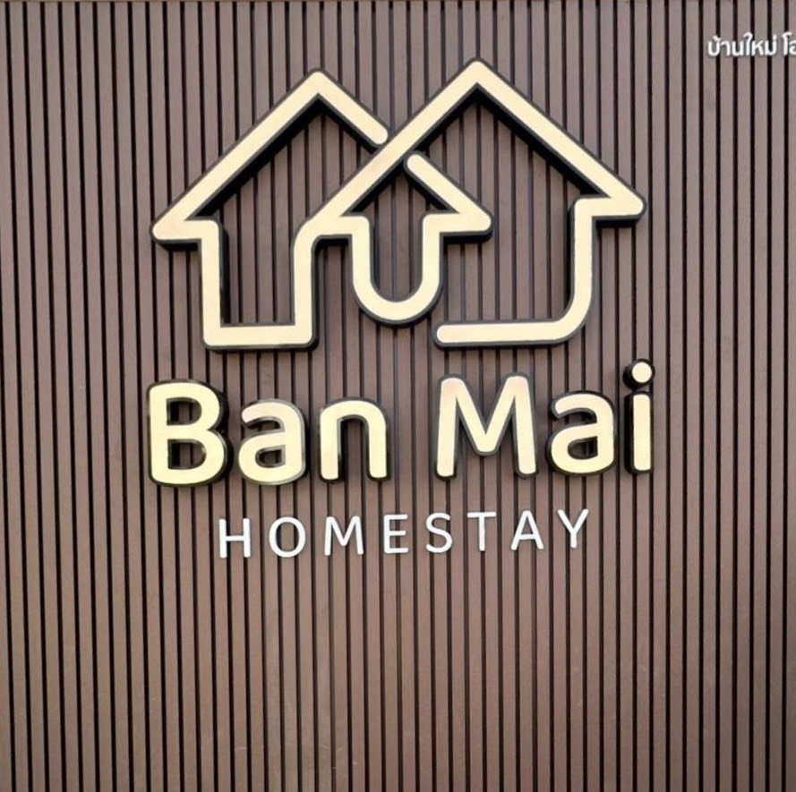 ป้ายโลโก้ Ban Mai Homestay บนผนังระแนงไม้
